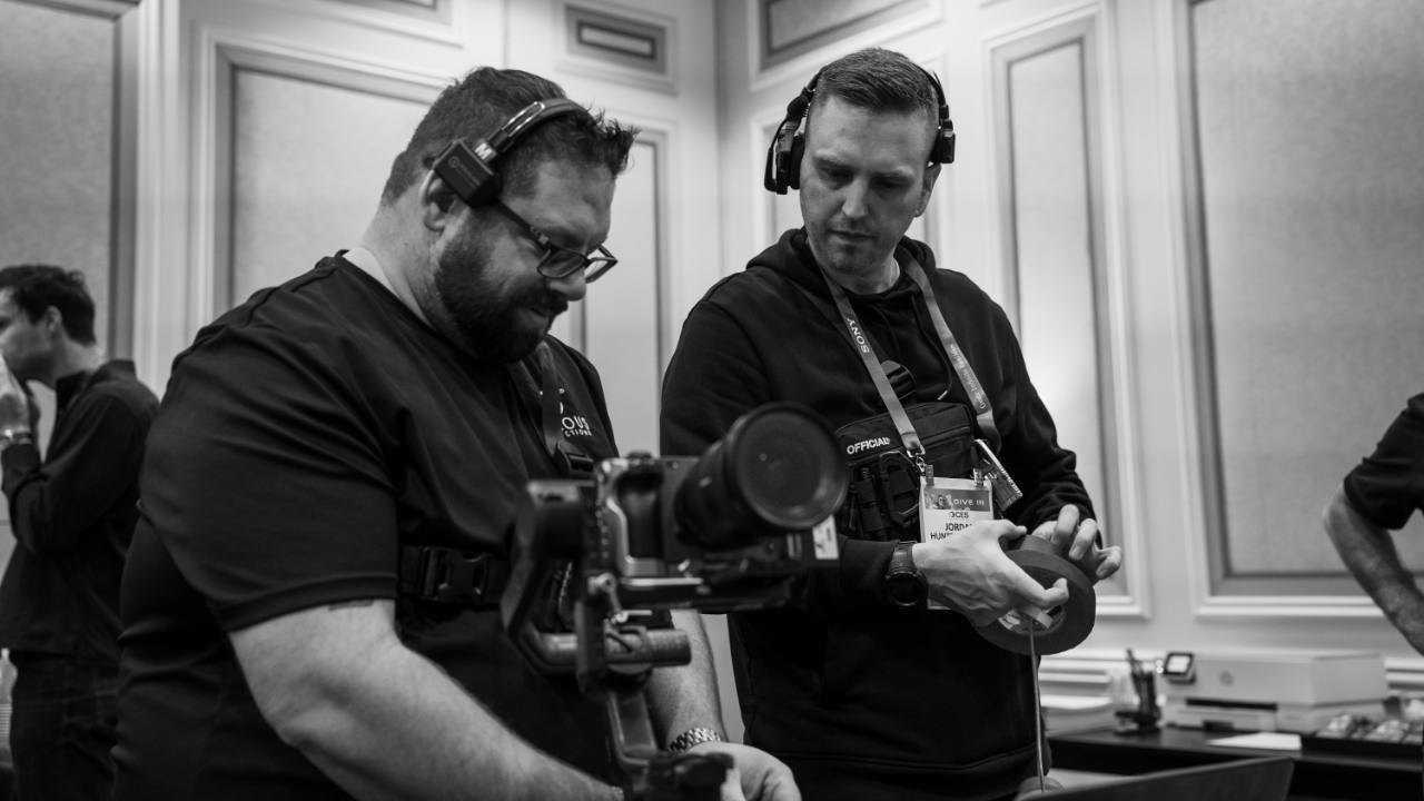 Crew preparing camera equipment at a convention